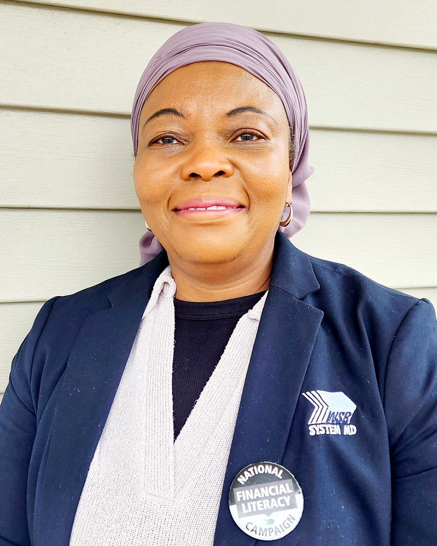 Rasheedatu Nyei, licensed financial advisor, smiling outdoors in a navy blazer